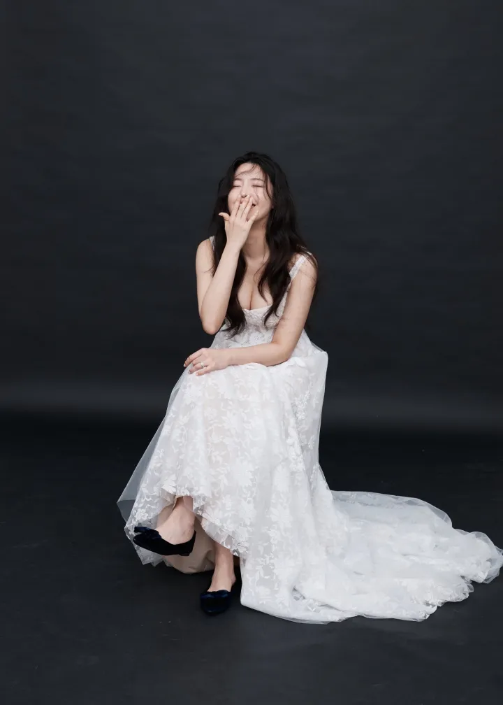 검은 배경 앞에서 웃는 신부